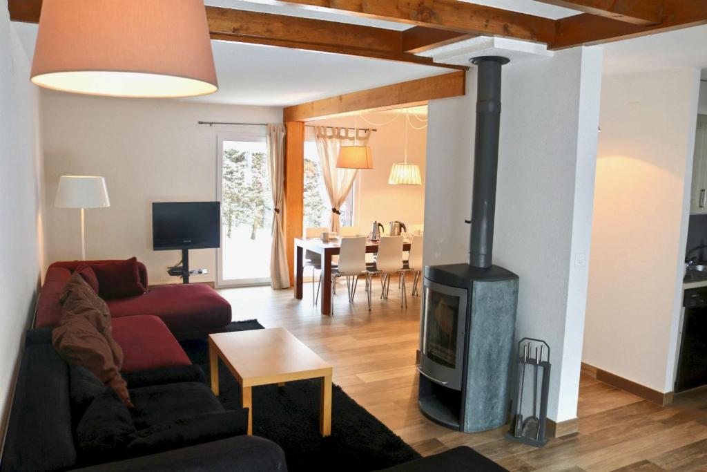 uma sala de estar com lareira e sofá em Au centre d'Ovronnaz - Chalet mitoyen em Ovronnaz