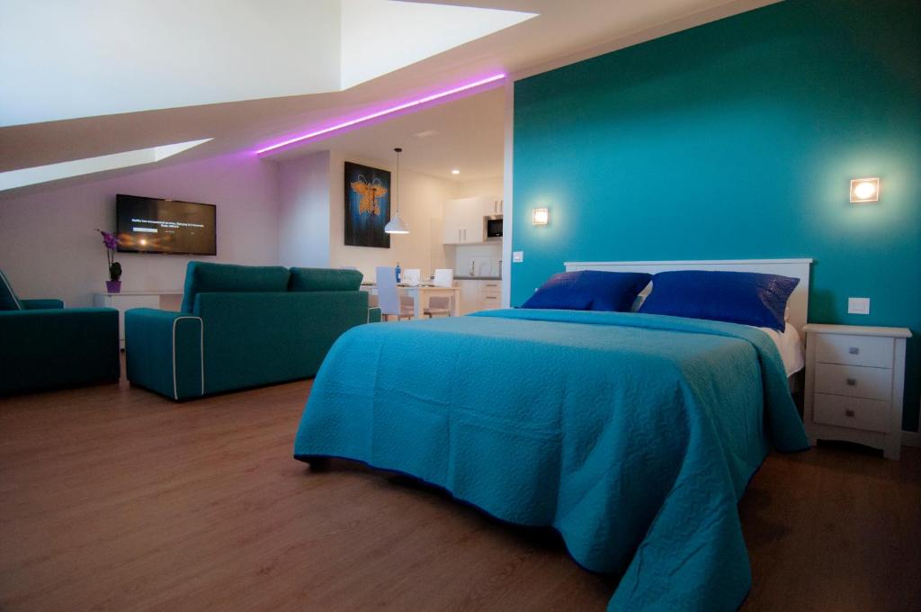 a blue bedroom with a bed and two green chairs at Los Rodeos Luxury Vivienda Vacacional in La Laguna