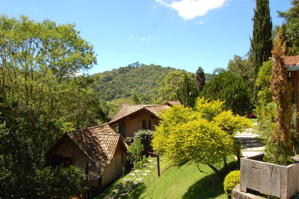 un jardín con una casa, árboles y una valla en Pássaro de Fogo, en Santo Antônio do Pinhal