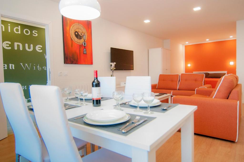 a dining room with a white table with a bottle of wine at Los Rodeos Luxury Vivienda Vacacional in La Laguna
