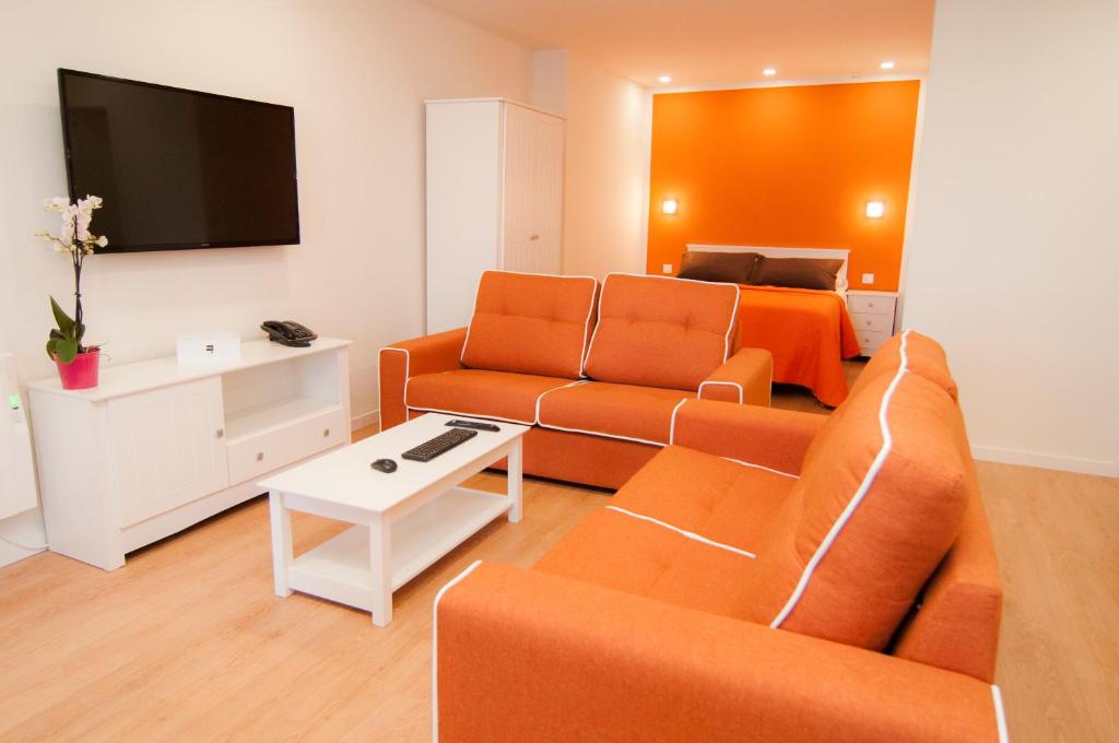 a living room with orange furniture and a bed at Los Rodeos Luxury Vivienda Vacacional in La Laguna