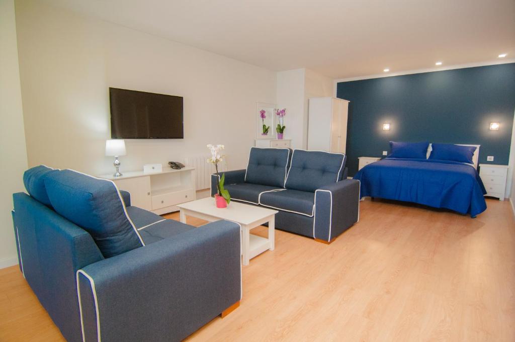 a living room with two blue chairs and a bed at Los Rodeos Luxury Vivienda Vacacional in La Laguna