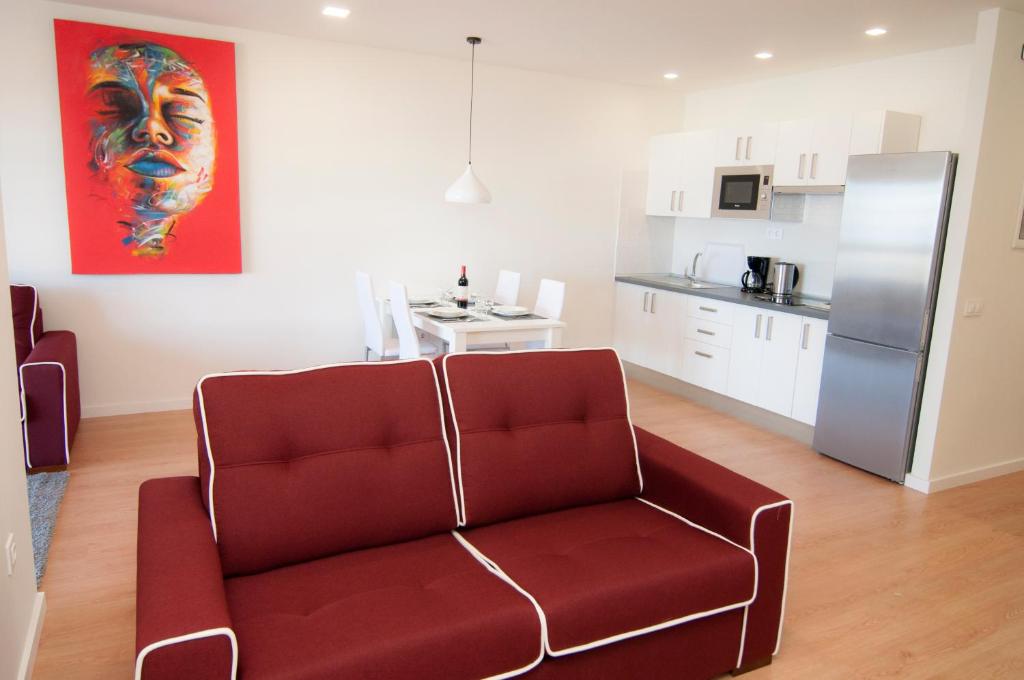 a living room with a red couch and a kitchen at Los Rodeos Luxury Vivienda Vacacional in La Laguna