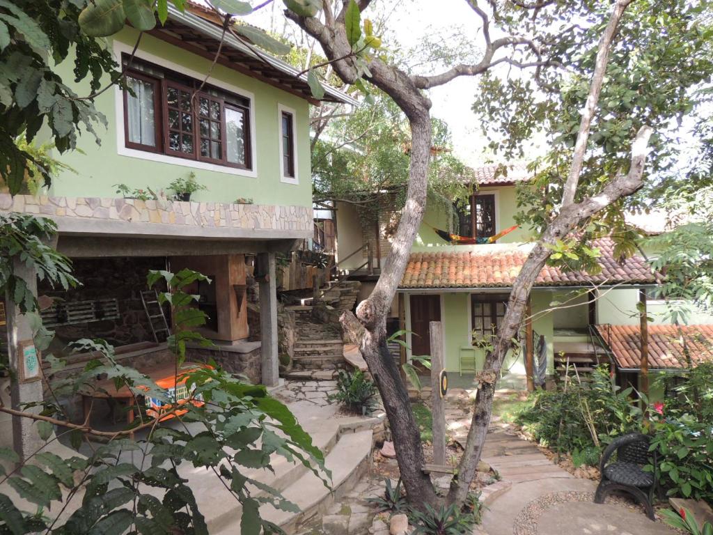 a house with a tree in front of it at Canto Verde Pousada in Lençóis