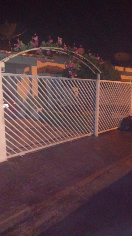 a white fence with flowers on top of it at Meu Cantinho da Paz Em Águas de Lindóia in Águas de Lindoia