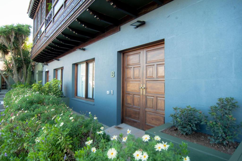 a blue house with a wooden door and some flowers at Los Rodeos Luxury Vivienda Vacacional in La Laguna