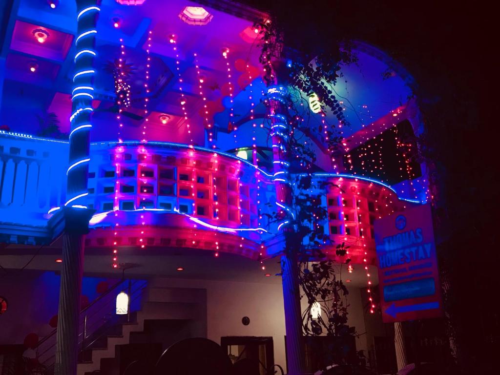 a building with red and blue lights on it at Thomas Home Stay in Agra