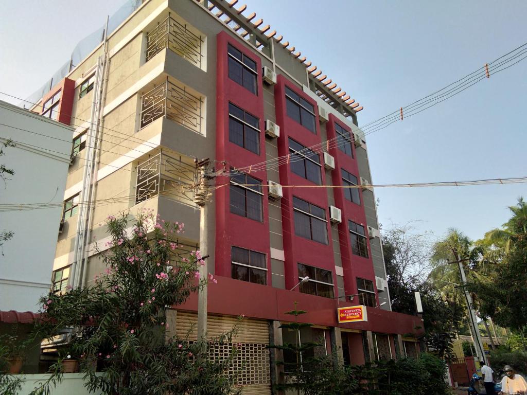 a red and white building on the side of a street at Aishvarya Residency Coimbatore in Coimbatore