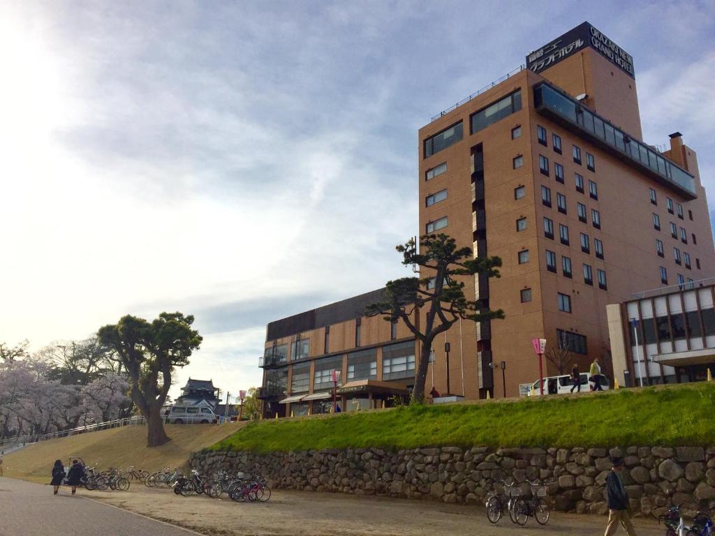 un edificio con un montón de bicicletas estacionadas frente a él en Okazaki New Grand Hotel, en Okazaki