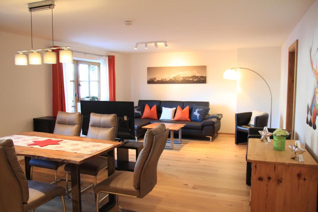 ein Wohnzimmer mit einem Tisch und einem Sofa in der Unterkunft Apartment "Künstlhäusl" in Jochberg