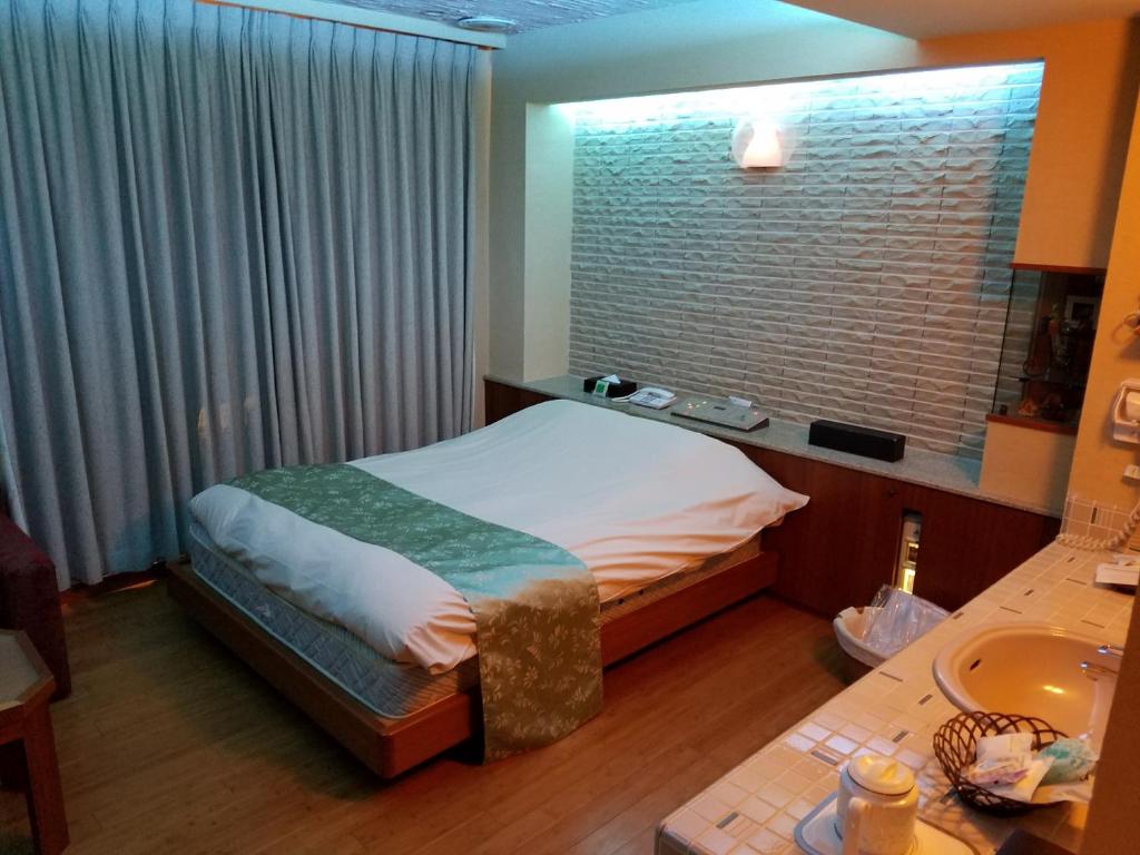 1 dormitorio con 1 cama con ventana y lavamanos en EIGHT PRINCE HOTEL -Adult Only-, en Tokorozawa