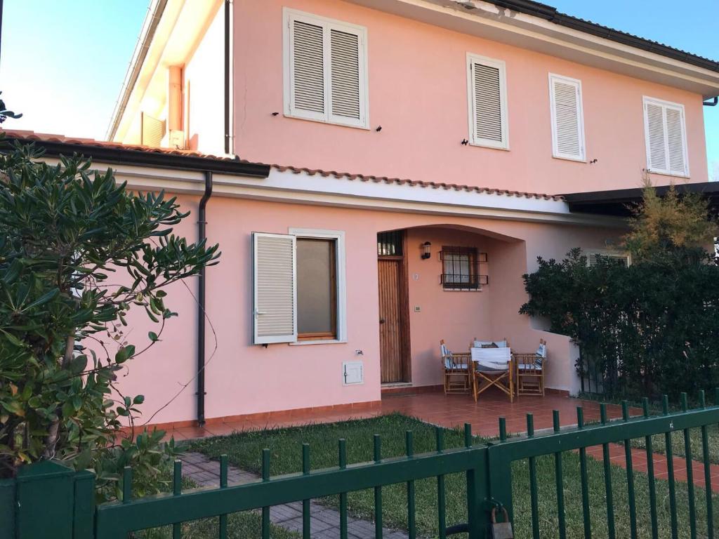 ein rosa Haus mit einem Zaun davor in der Unterkunft Il terrazzino di Lulù in Cetraro