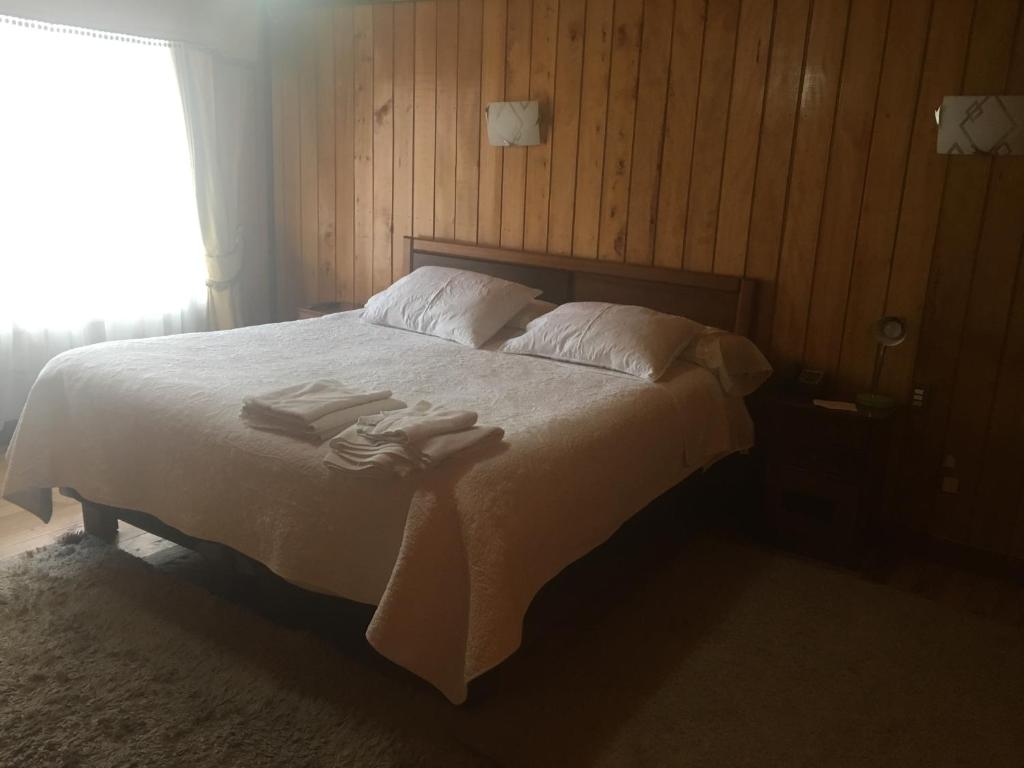 1 dormitorio con 1 cama con 2 toallas en Hostal Florencia en Hornopiren
