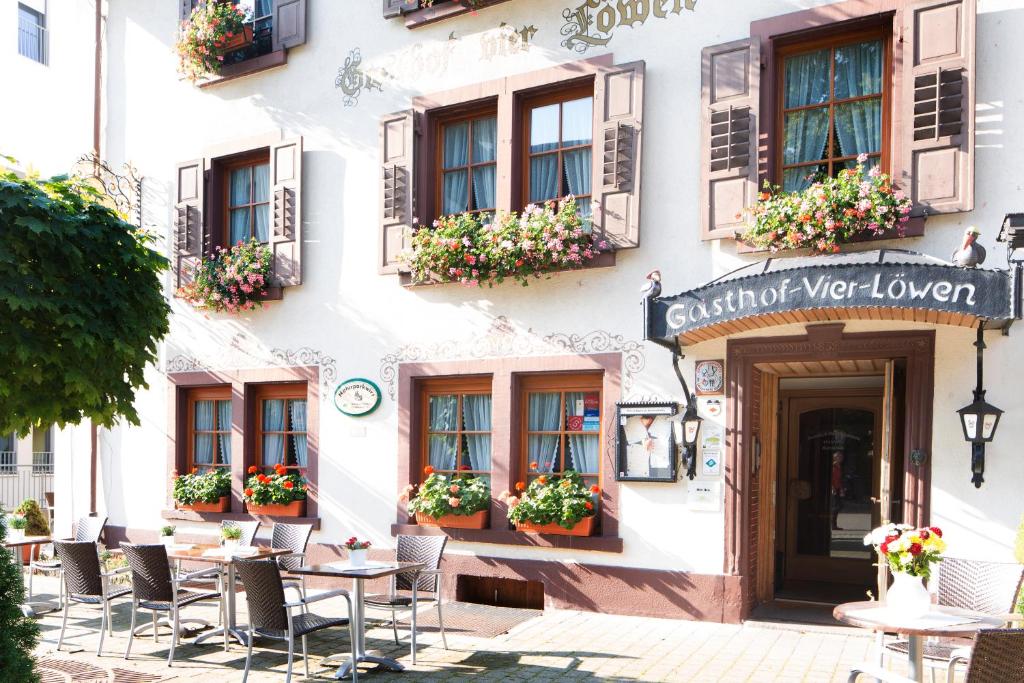 un edificio con mesas y sillas delante de él en Vier Löwen en Schönau im Schwarzwald