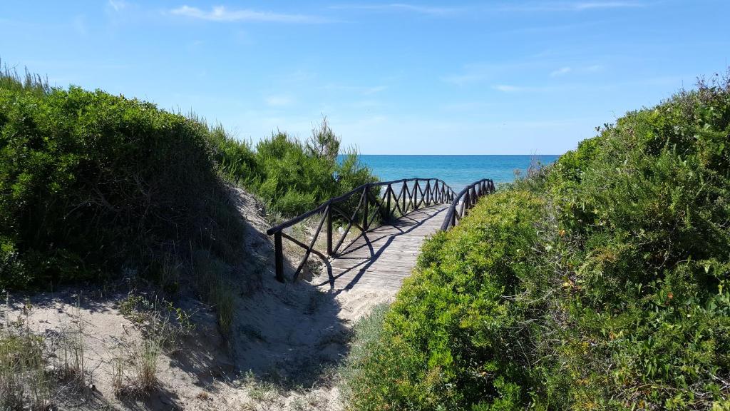 un sentiero in legno che conduce all'oceano su una spiaggia di Camping Villaggio Riviera a Foce Varano