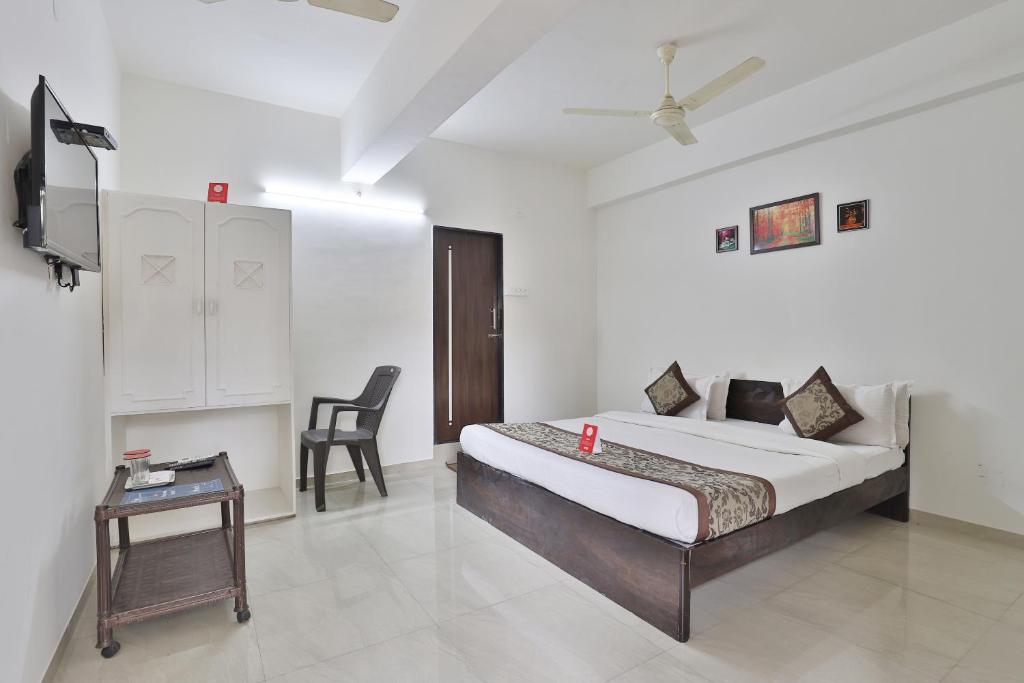 a bedroom with a bed and a table and a tv at Nova Hotel Star Palace in Rajkot