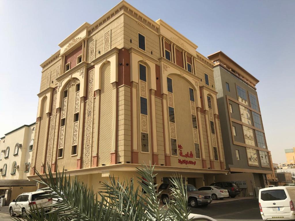 a large building with cars parked in a parking lot at شامة جدة للشقق المخدومة in Jeddah