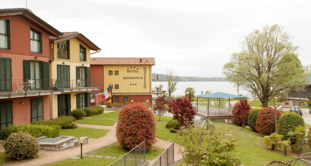 a building with a garden in front of a lake at Hotel Residence Montelago in Ternate