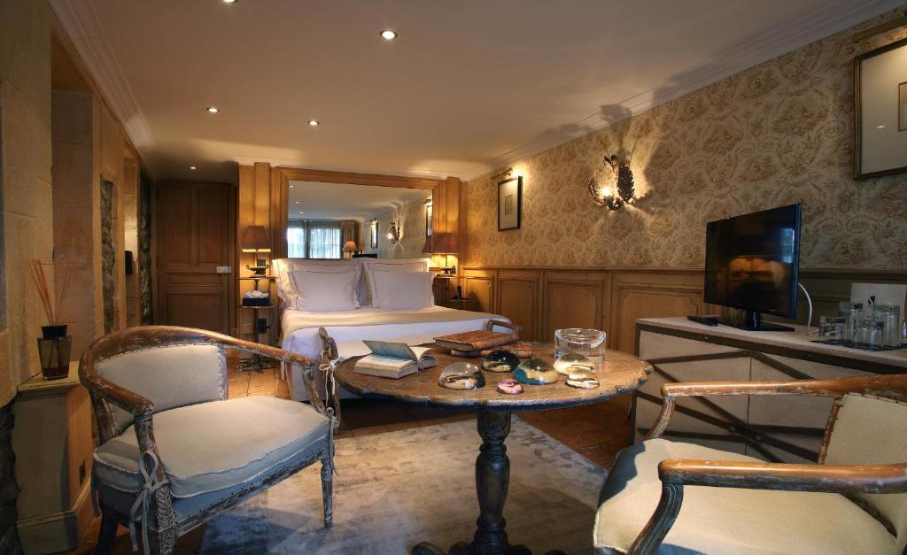 une chambre d'hôtel avec un lit, une table et des chaises dans l'établissement Le Saint Joseph, à Courchevel