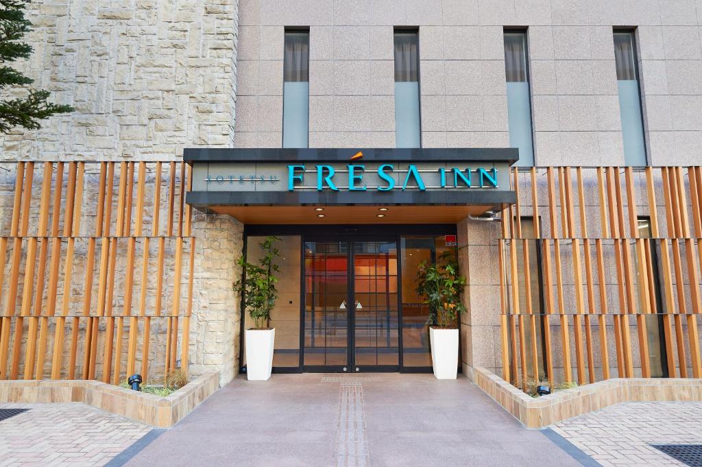 una entrada a un edificio con un cartel en Sotetsu Fresa Inn Tokyo Tamachi en Tokio