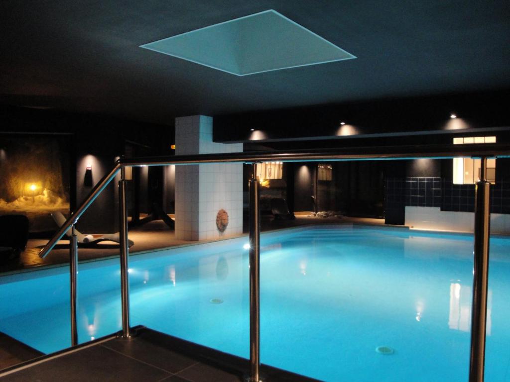 a large swimming pool in a building at night at Chalet Hôtel du Bois in Les Houches