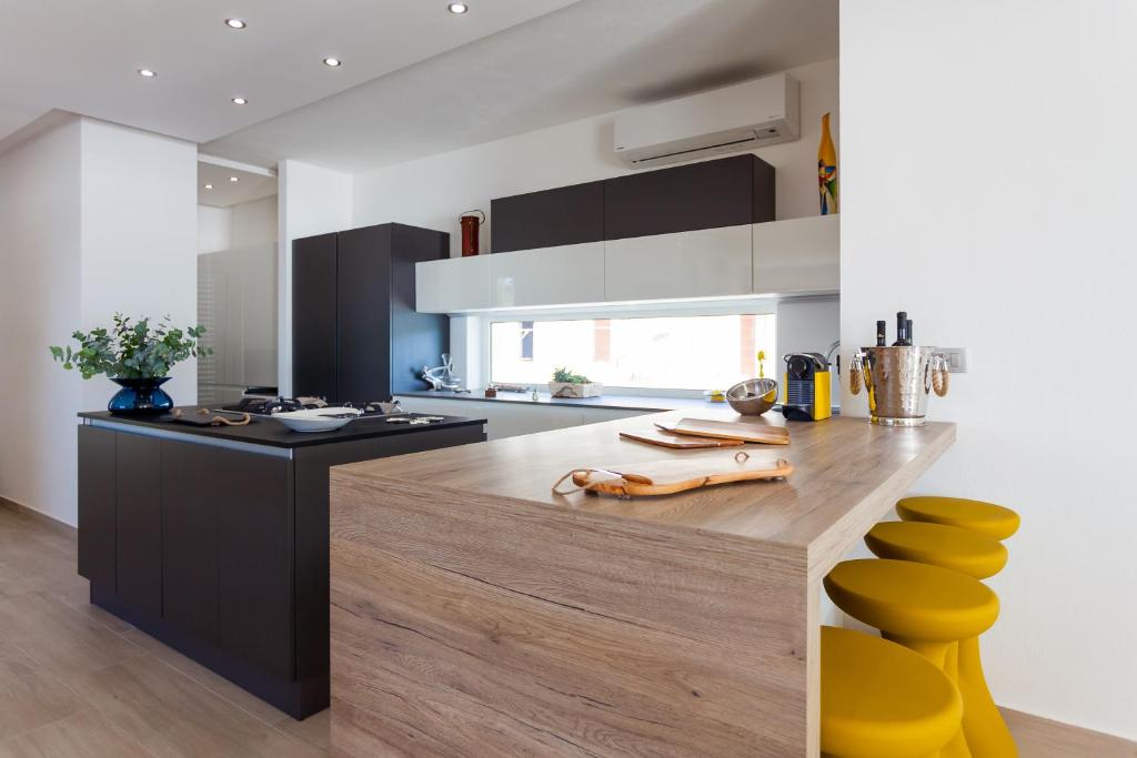 a kitchen with a counter with yellow stools at Villa Soleil in Vela Luka