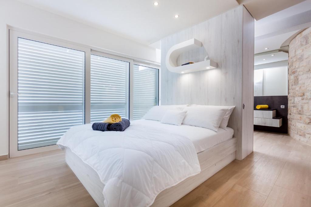 a bedroom with a large white bed with a teddy bear on it at Villa Soleil in Vela Luka