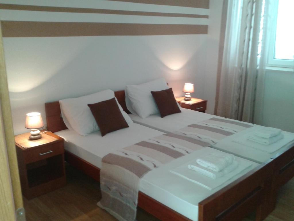 ein Schlafzimmer mit 2 Betten und 2 Lampen an Tischen in der Unterkunft Apartments Dalmatino in Dubrovnik