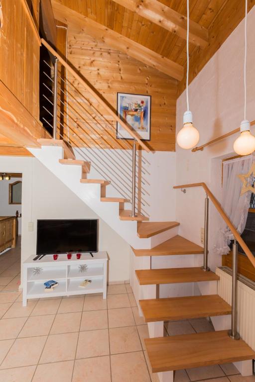 a staircase in a living room with wooden ceilings at DEVA Hotel Kaiserblick in Reit im Winkl