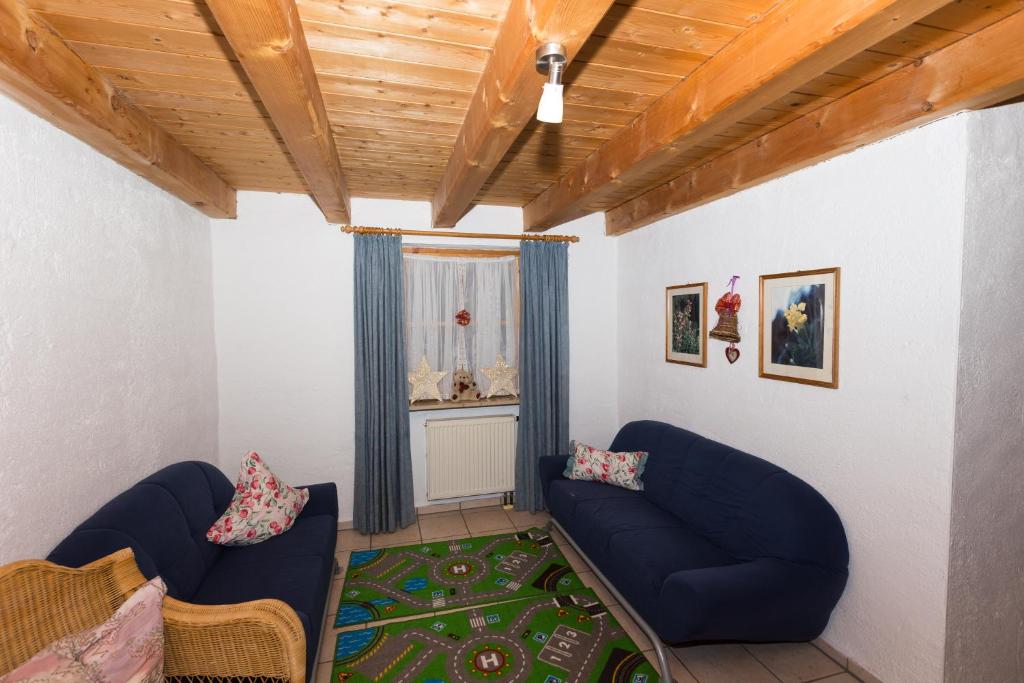 a living room with two blue couches and a window at DEVA Hotel Kaiserblick in Reit im Winkl