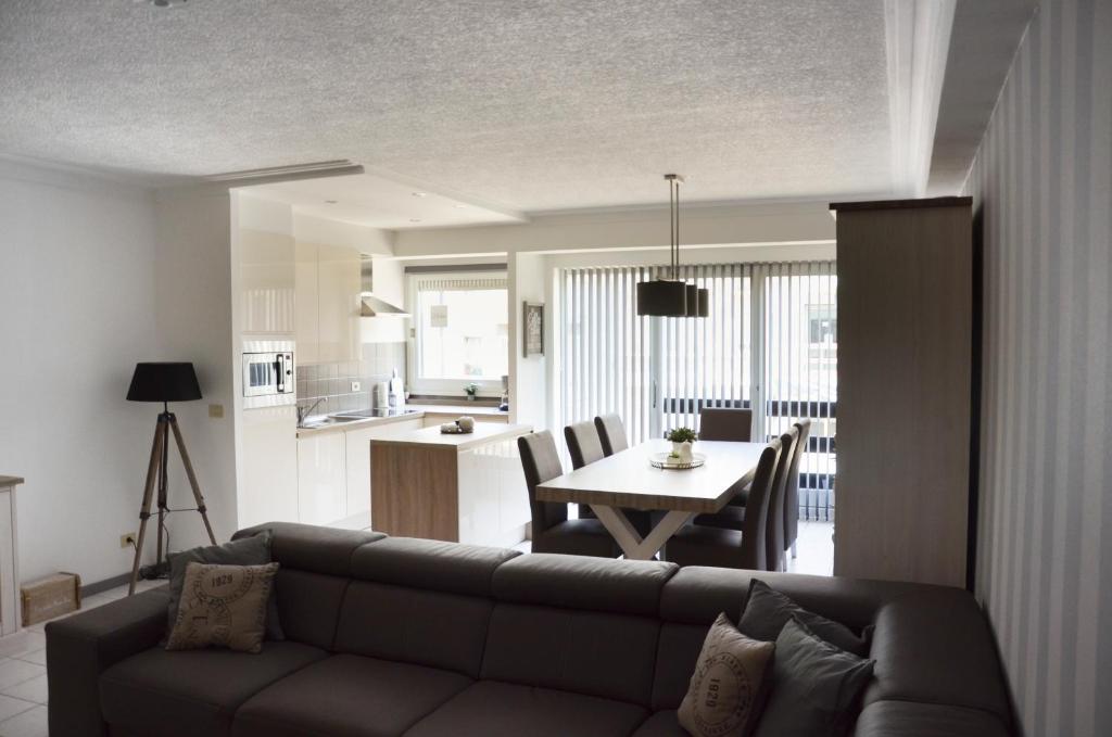 un soggiorno con divano e tavolo di Oostende Appartement a Ostenda