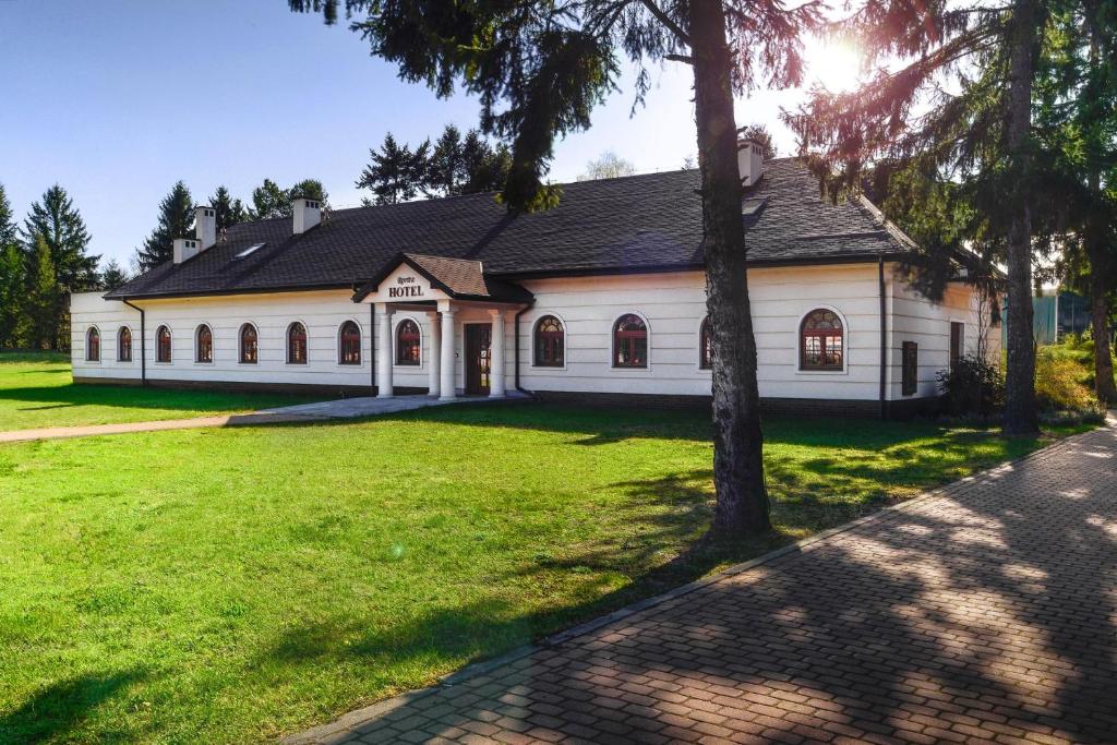 una gran casa blanca con un gran patio de césped en Revita en Józefów