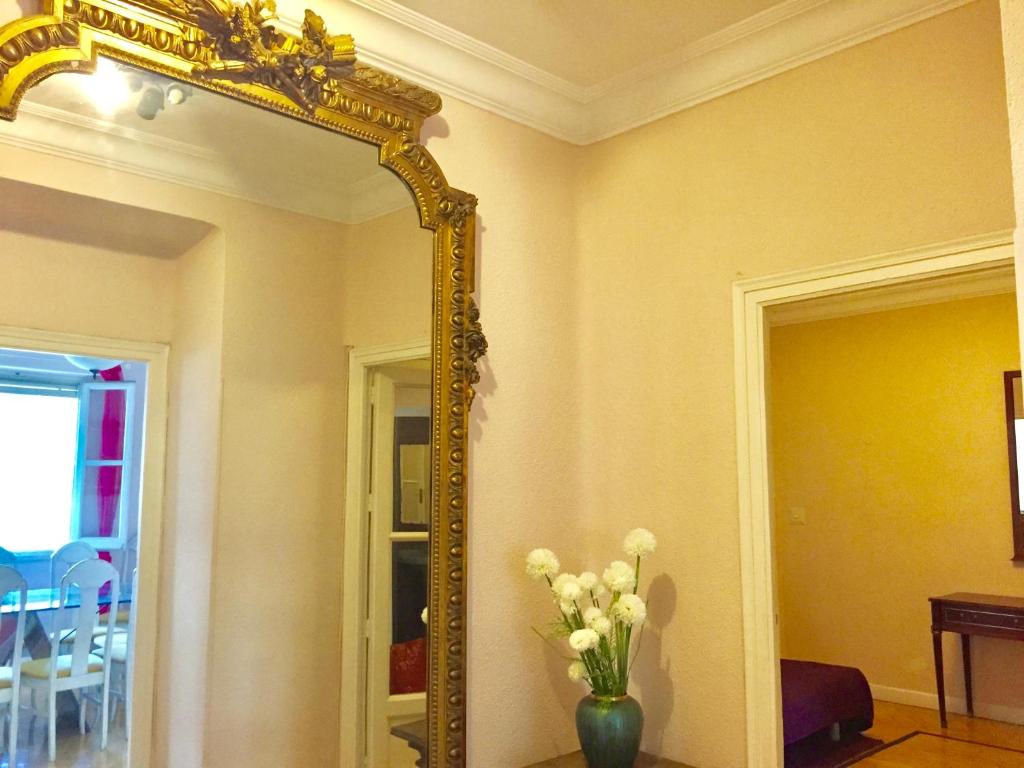 - un miroir dans une chambre avec un vase de fleurs dans l'établissement Madrid Business El Viso, à Madrid