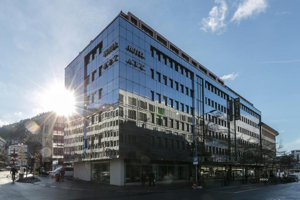un grand bâtiment en verre sur une rue de la ville dans l'établissement ABC Swiss Quality Hotel, à Coire