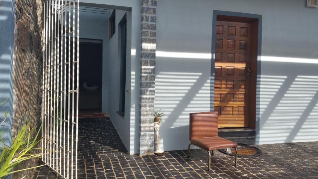 a cat sitting next to a chair on a porch at Casa da Lúcia in Uberlândia