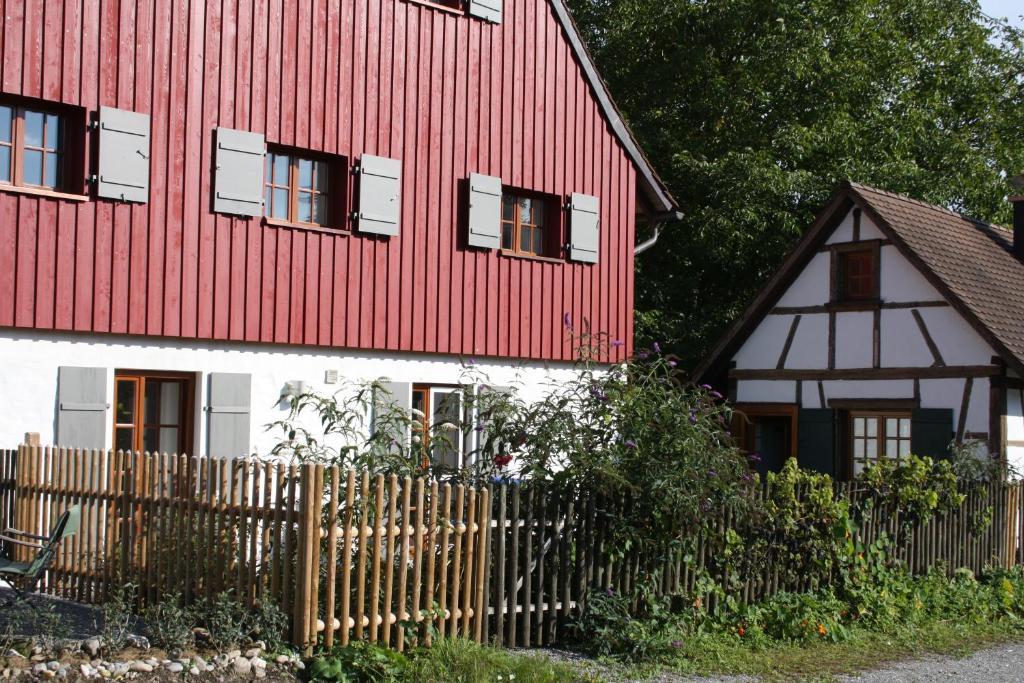 una casa roja y blanca con una valla de madera en Ferienwohnung Hornauer en Salem