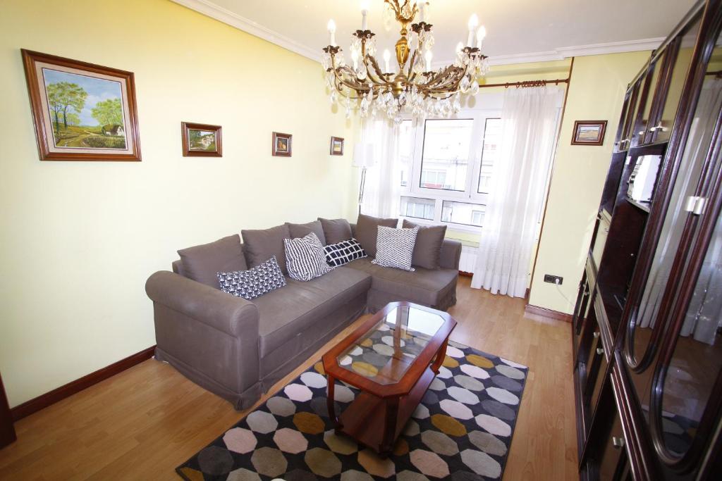 sala de estar con sofá y mesa en Apartamento con encanto y vistas en playa San Lorenzo, en Gijón