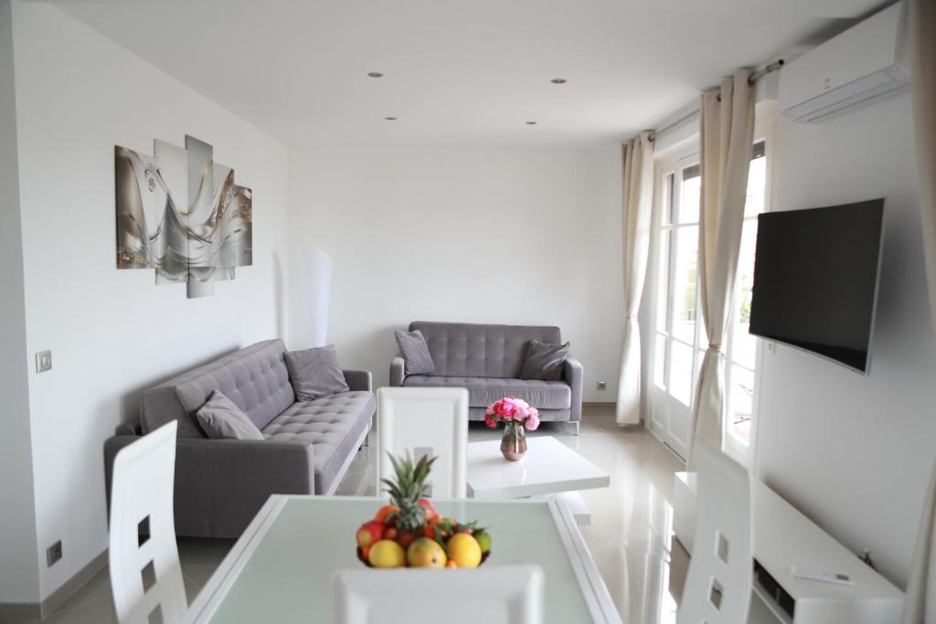 - un salon avec un canapé et une table avec des fruits dans l'établissement 3P luxe proche Croisette, à Cannes