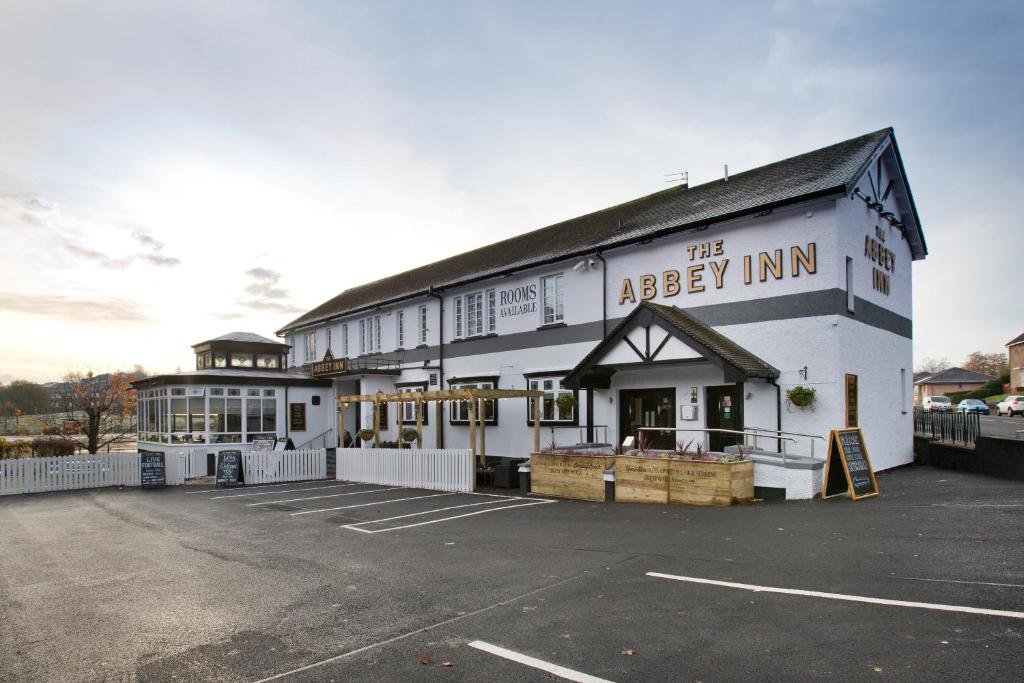 un grande edificio bianco con la locanda dell'abbazia di The Abbey Inn a Paisley