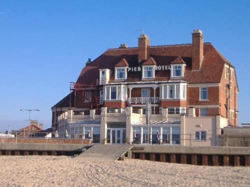 a large building on the beach next to the beach at Pier Hotel in Great Yarmouth
