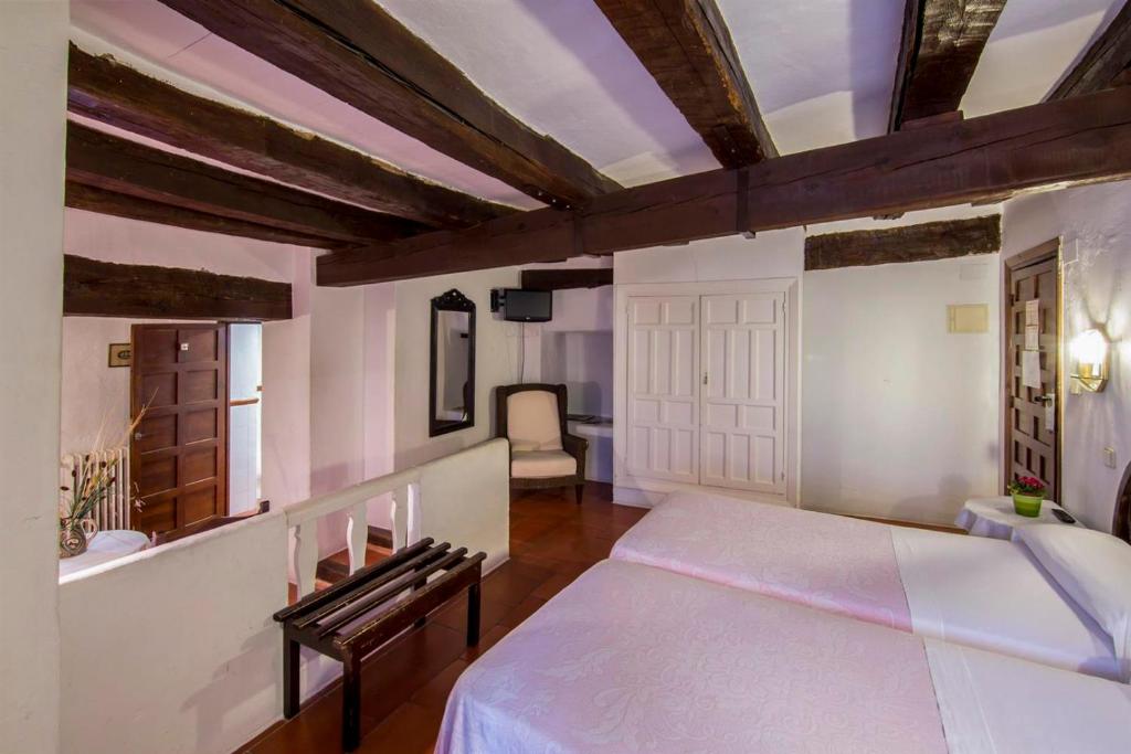 Un dormitorio con una cama grande en una habitación con techos de madera. en Posada San José, en Cuenca