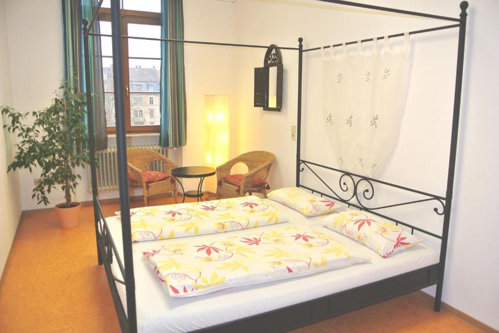 1 dormitorio con 1 cama con 4 almohadas en Steffis Hostel Heidelberg en Heidelberg