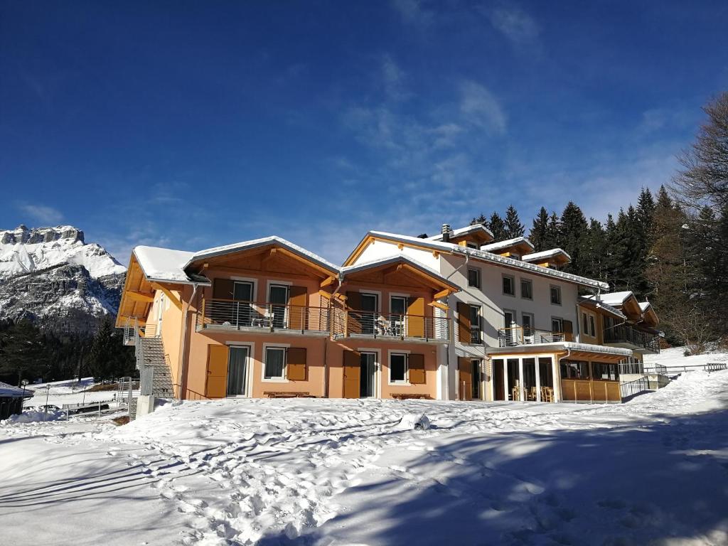 a house in the snow in the mountains at Hotel Elbele Garnì in Folgaria