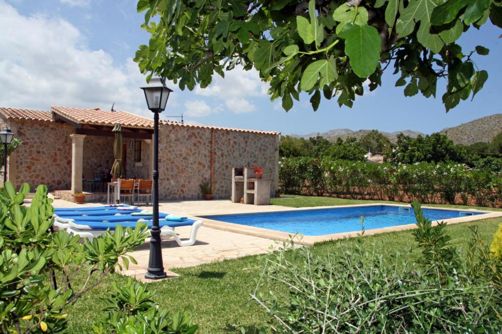 a villa with a swimming pool in a yard at Ca Na Cati in Pollença