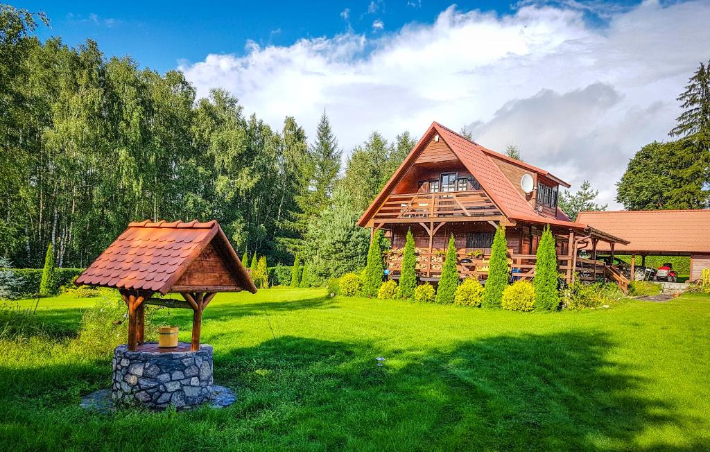 una casa de madera con cenador en el patio en Sznureczki, en Przewóz