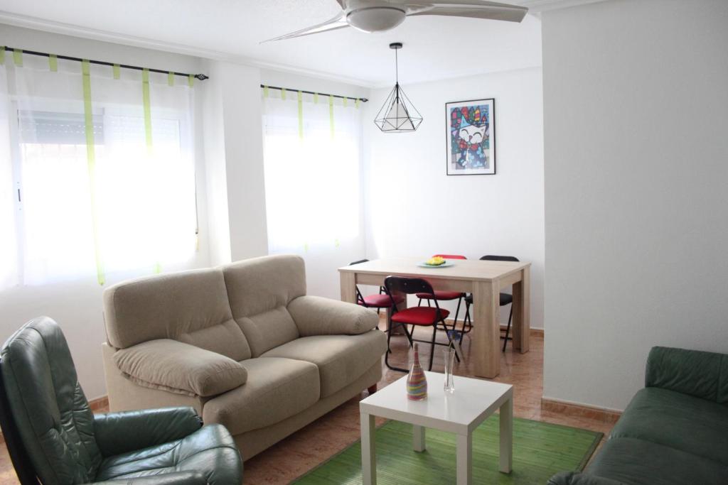 uma sala de estar com um sofá e uma mesa em Apartamento Auditorio em Alicante