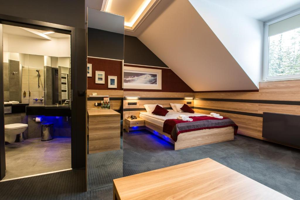 een slaapkamer met een bed en een badkamer bij Villa Winterpol in Karpacz