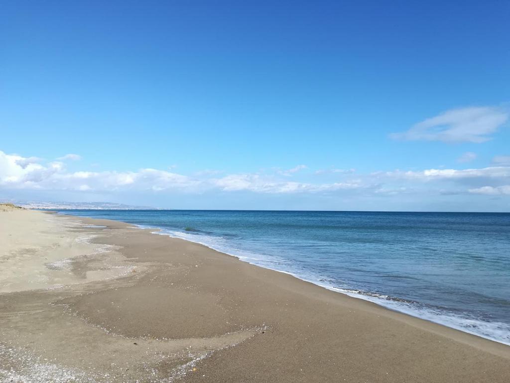 a beach with the ocean on a sunny day at Seaside village Catania in Catania