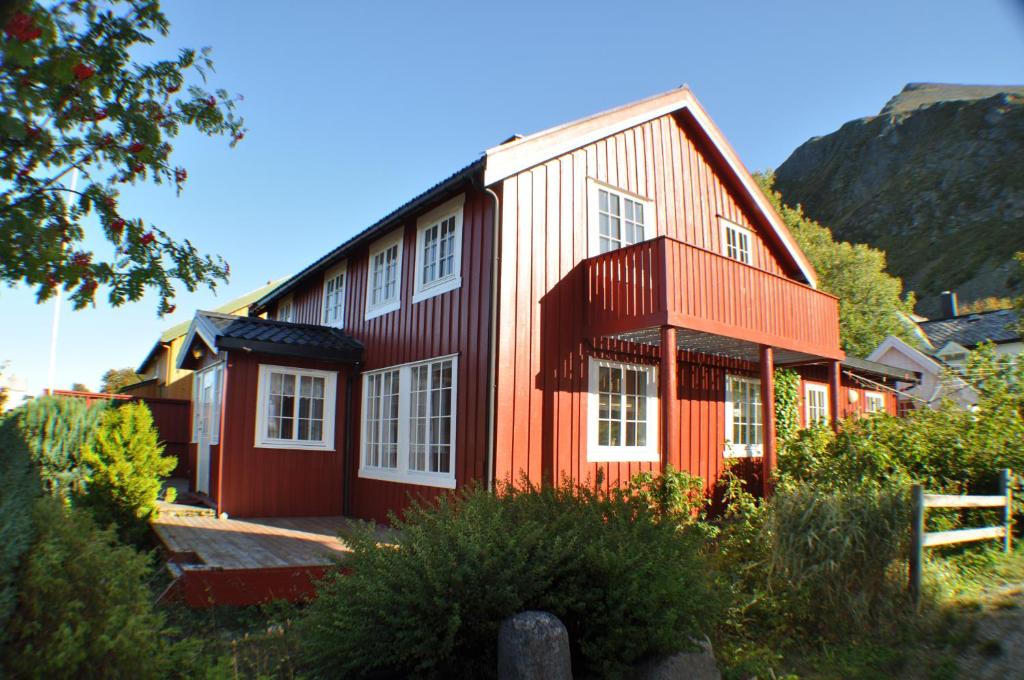 une maison rouge avec des fenêtres blanches sur une montagne dans l'établissement 5-Bedroom House in Lofoten, à Ramberg