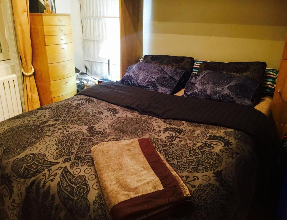 un lit avec une couette et des oreillers dessus dans l'établissement Quartier Montorgueil, voie piétonne, dans un immeuble du XVème, à Paris